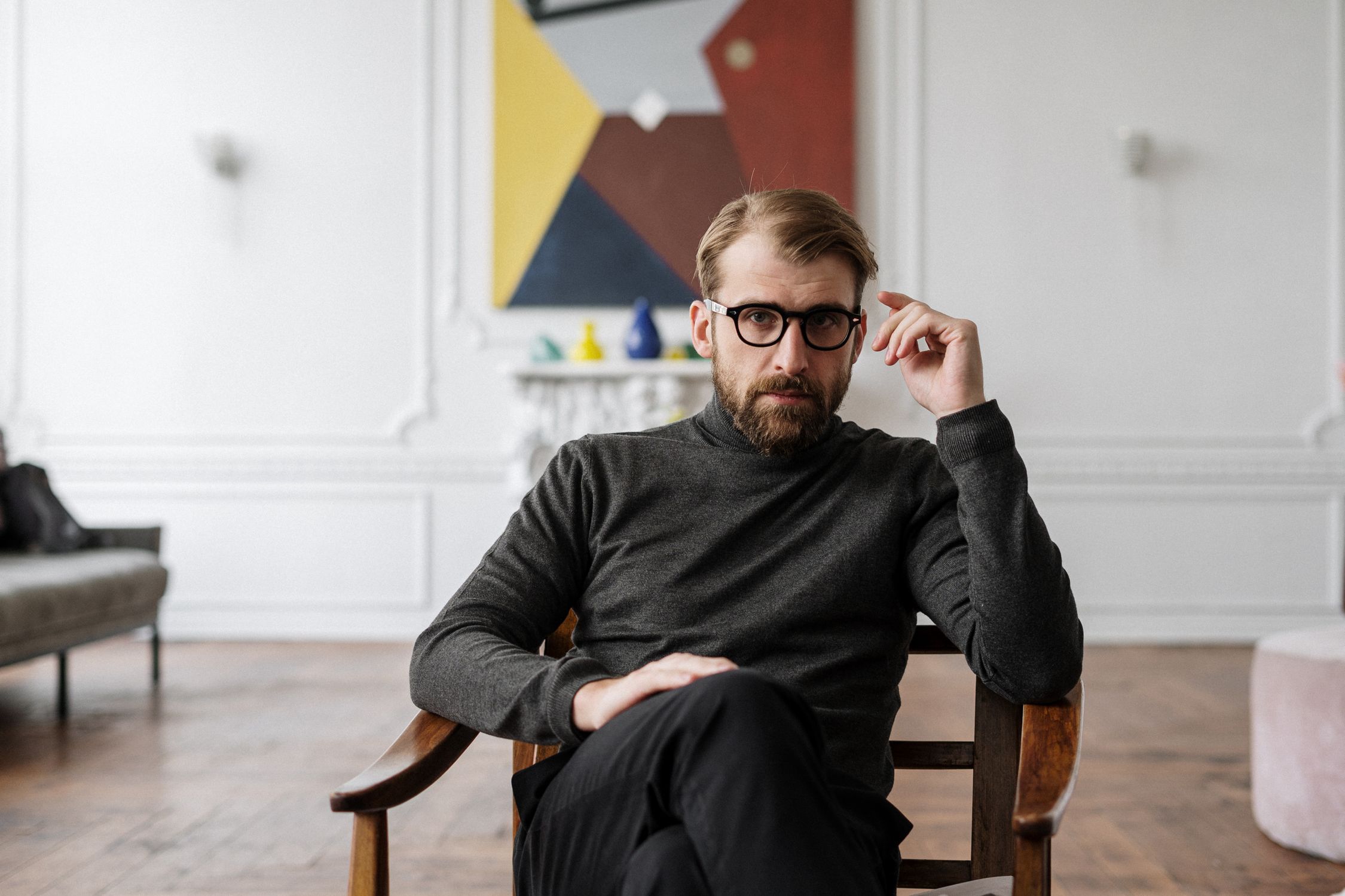 Man in Black Sweater Sitting on Brown Wooden Chair physical trait linked to narcissism